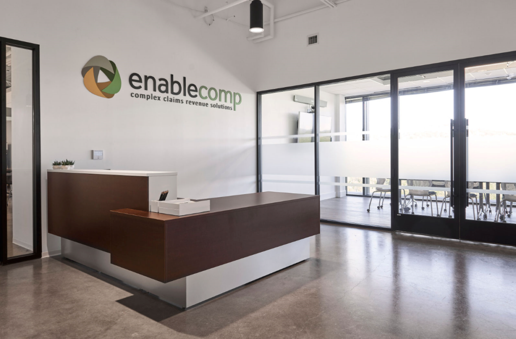 EnableComp reception room with EnableComp Logo above reception desk | EnableComp Available Nationwide