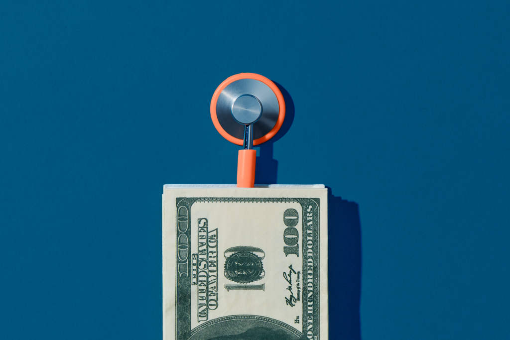 Stethoscope and money on blue background | EnableComp is available across the United States.